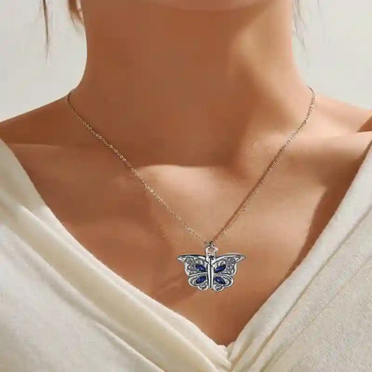 Butterfly pendant necklace on a person wearing a white top