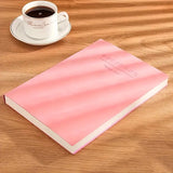 Pink notebook on a wooden table with a cup of coffee