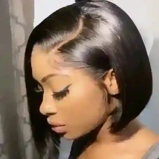 Person with styled hair looking downwards against a neutral background